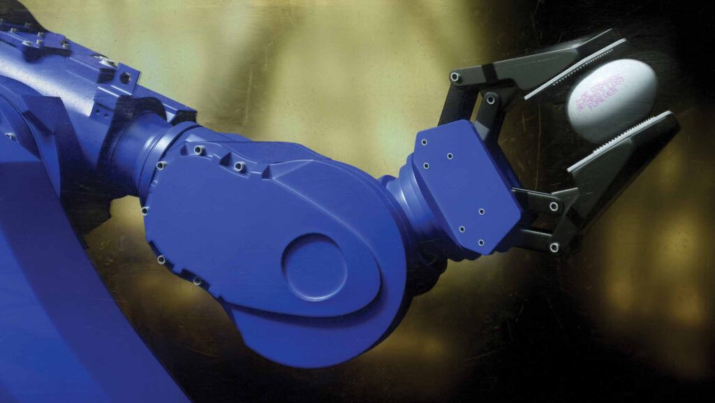 Photo of robotic arm with an egg in between its two claws that has an engraving which reads "Nothing is lost forever."