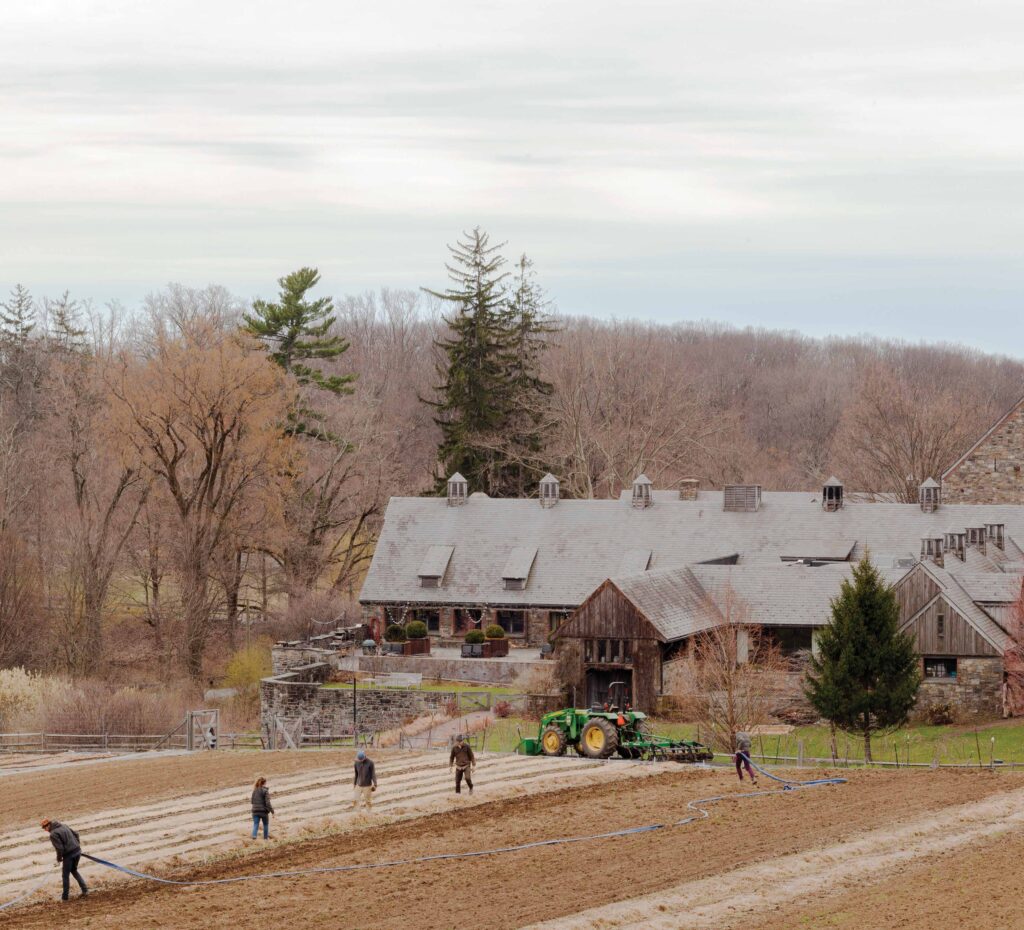 Photo of a large barn and farmhouse with tractor in front of it.