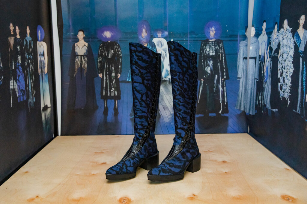 Two knee high boots with blue and black zebra-like cross hatching