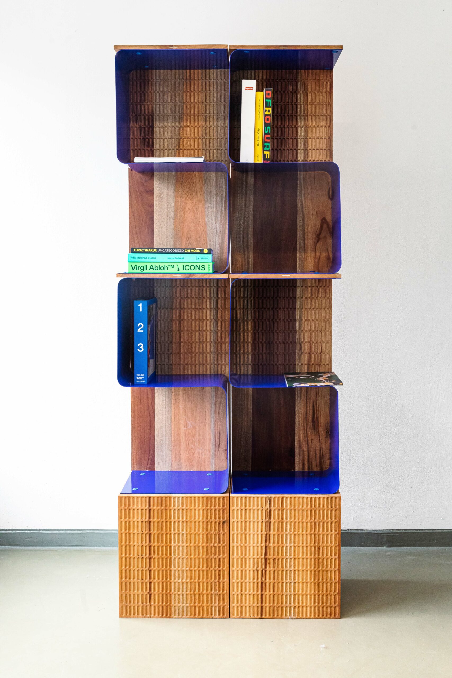 A book shelf made of wood and bent blue plastic.