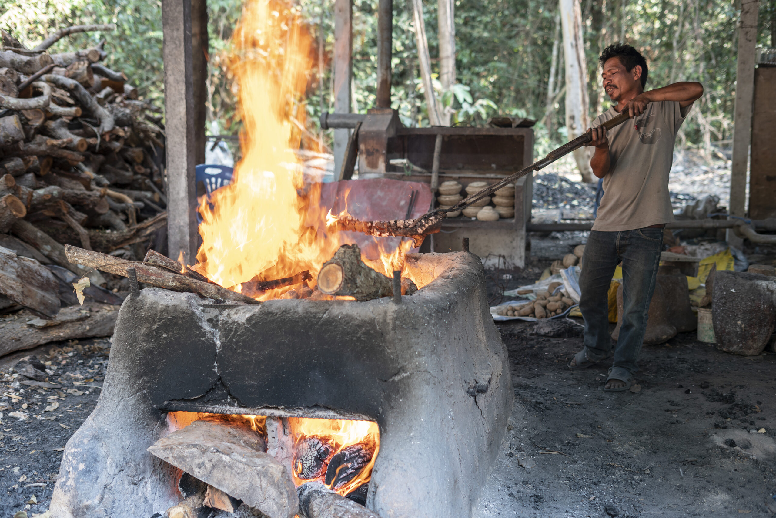 A man stokes the fire he is using to heat up brass casting molds.