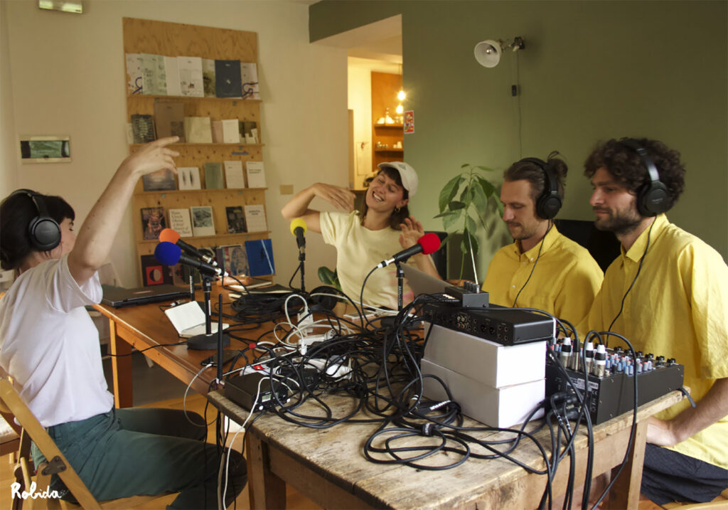 4 people sit around a table with microphones and radio transmitter