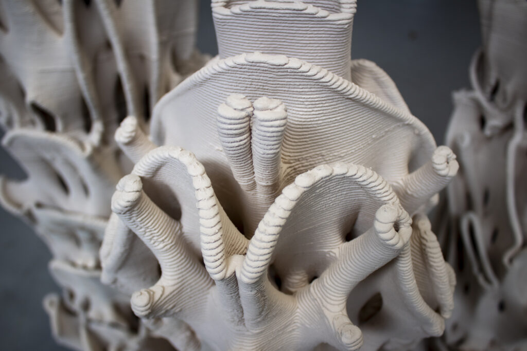 A close-up of a coral-like white sculpture with white ridged surfaces.