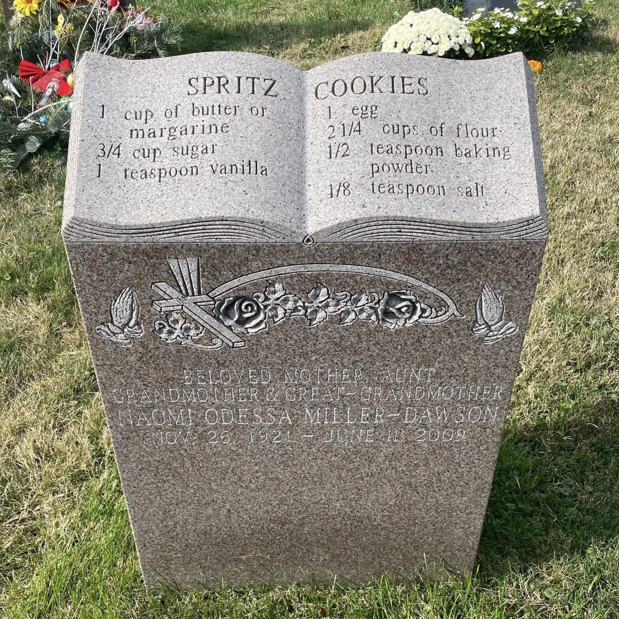 A gravestone designed to look like an open book with the recipe for spritz cookies.