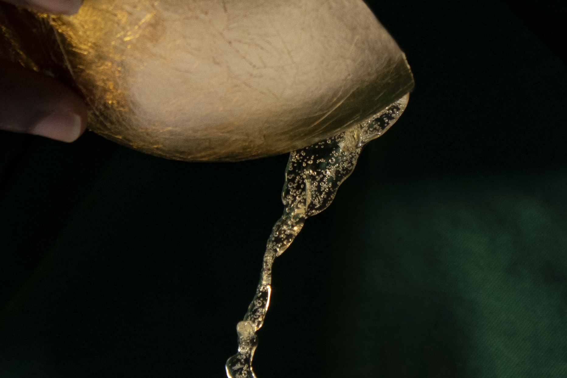 A golden chalice pours out bubbling yellow-ish palm wine.