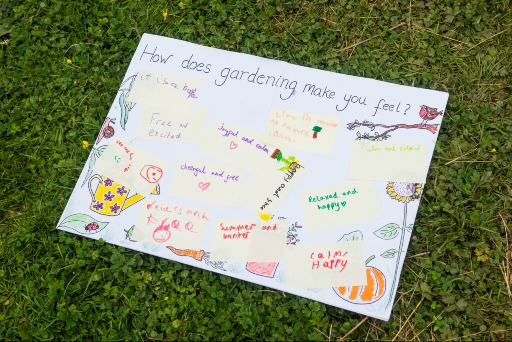 A poster with post-it notes answering the prompt How does Gardening Make You Feel?